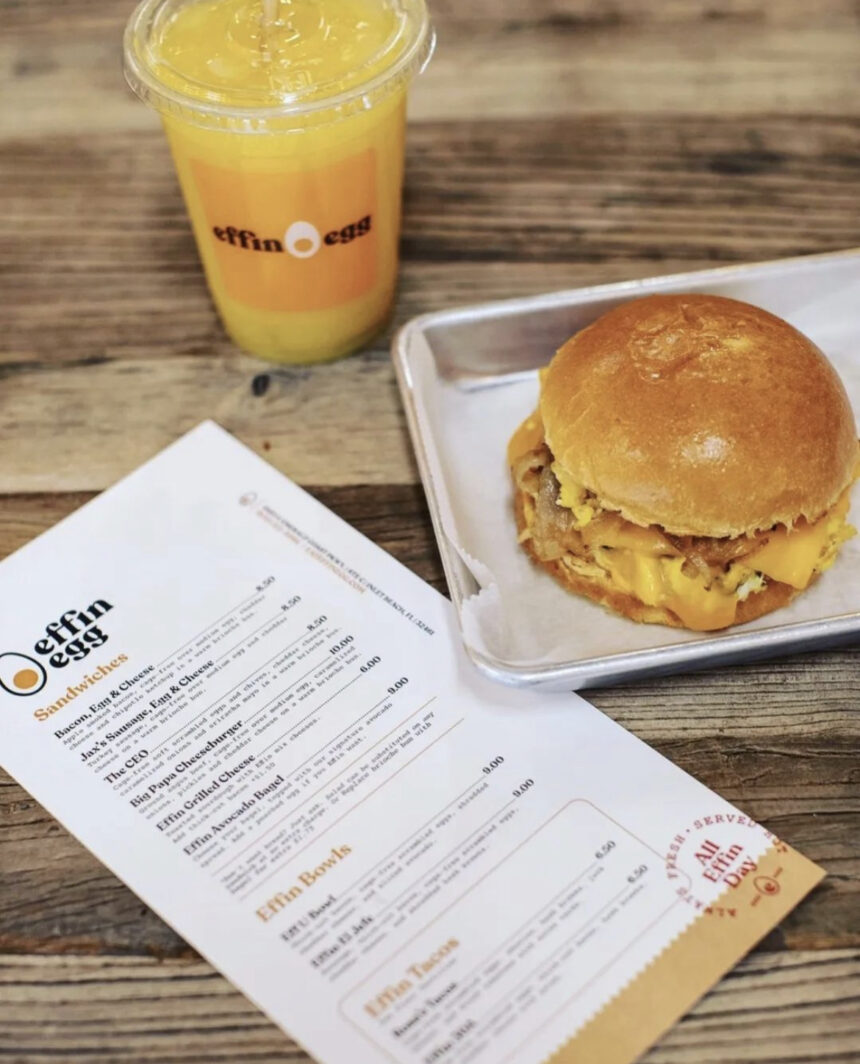 Photo of breakfast sandwich, orange juice and restaurant menu.